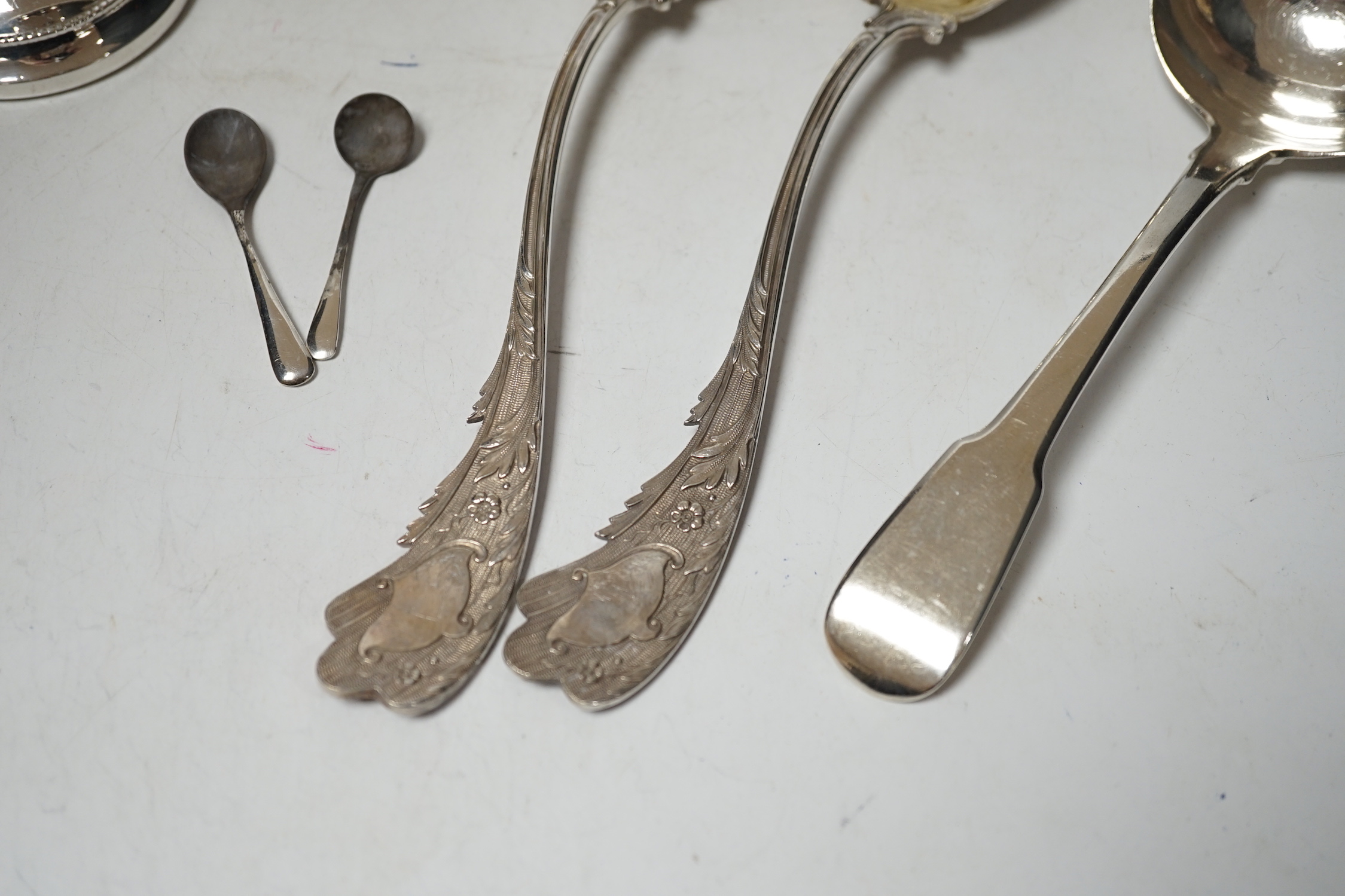 A pair of late Victorian silver serving spoons, with wavy foliate handles, Sheffield, 1897, 22.7cm, three other silver spoons and a pair of silver mounted dwarf candlesticks.